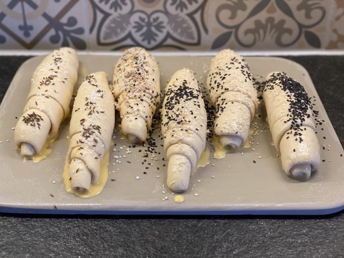 Salzstangen vor dem Backen, bepinselt und bestreut